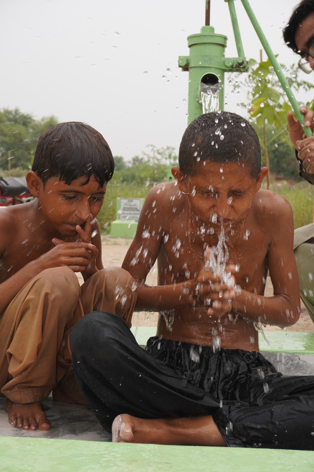 Children enjoying clean water from a new hand pump